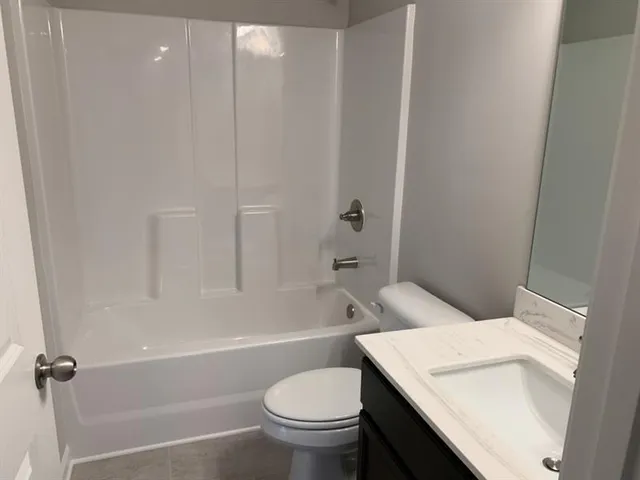 a white toilet sitting next to a bath tub