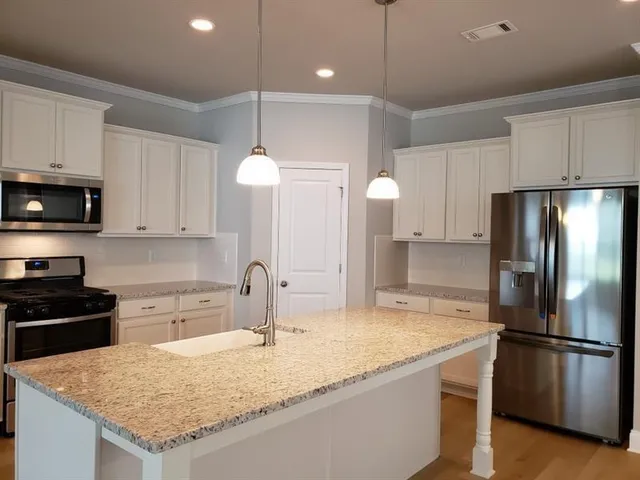 a kitchen with stainless steel appliances granite countertop a sink refrigerator and microwave