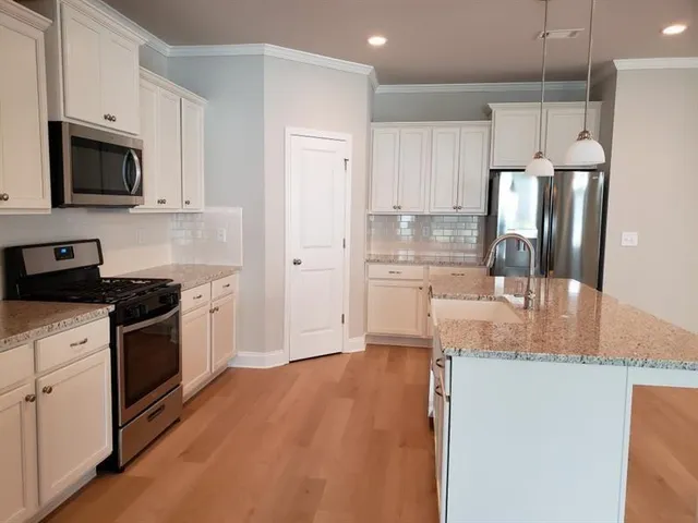a kitchen with stainless steel appliances granite countertop a refrigerator sink and stove