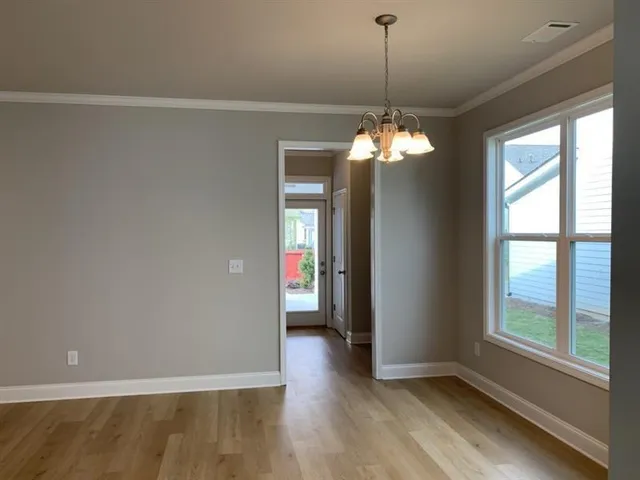a view of a room with wooden floor and chandelier
