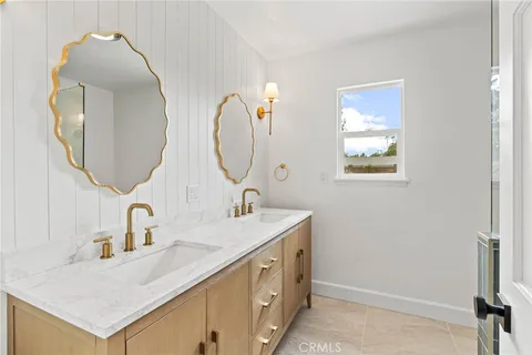 a bathroom with a double vanity sink and a mirror