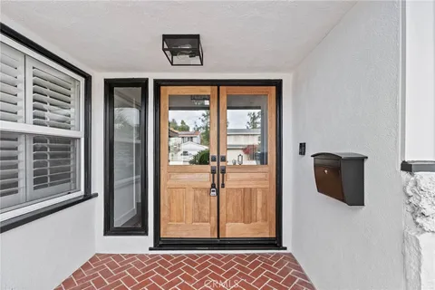 a view of a hallway with wooden floor and cabinet
