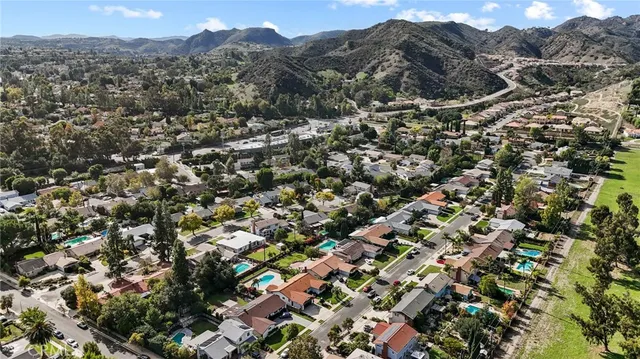 an aerial view of residential houses with outdoor space and trees