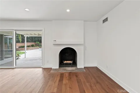 a view of a livingroom with wooden floor and a fireplace