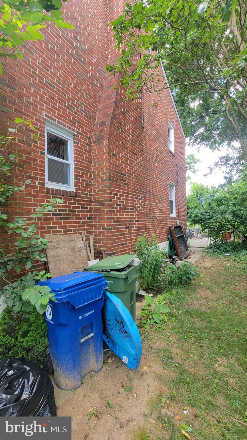 5105 Plymouth Road Baltimore, MD 21214 - Photo 5 of 29 Lush greenery frames a cozy brick facade.