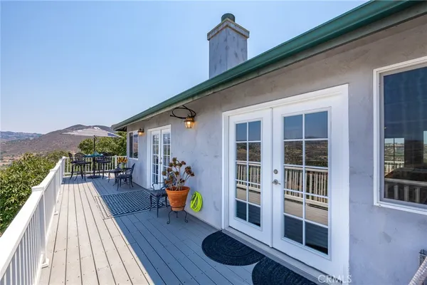 a view of a deck with couches floor to ceiling window and wooden floor