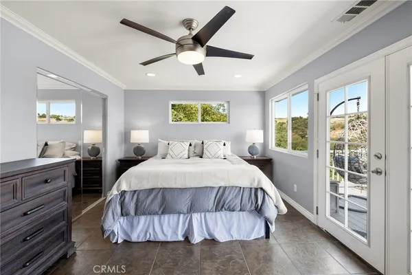 a spacious bedroom with a large bed and a chandelier