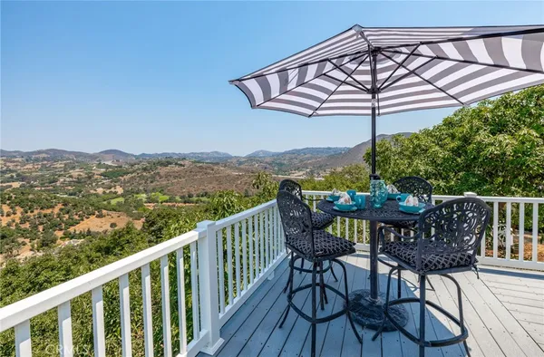 a view of a chairs and table on the roof deck