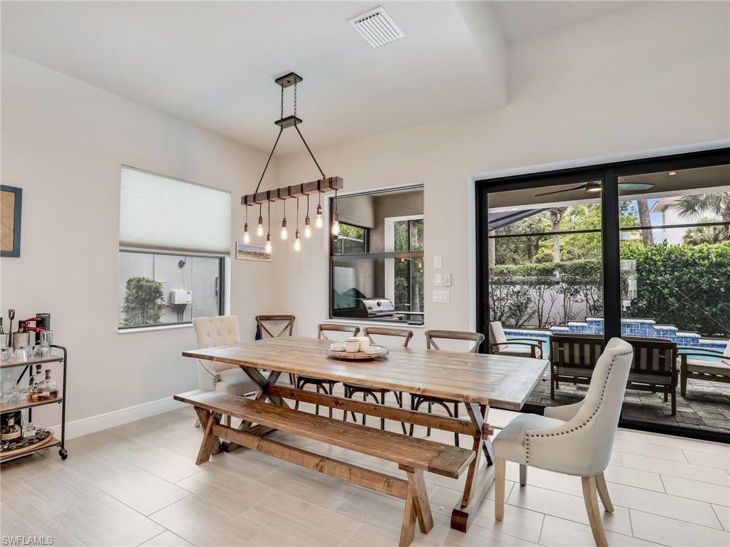 10047 Florence Circle Naples, FL 34119 - Photo 14 of 37 a dining room with furniture a chandelier and window