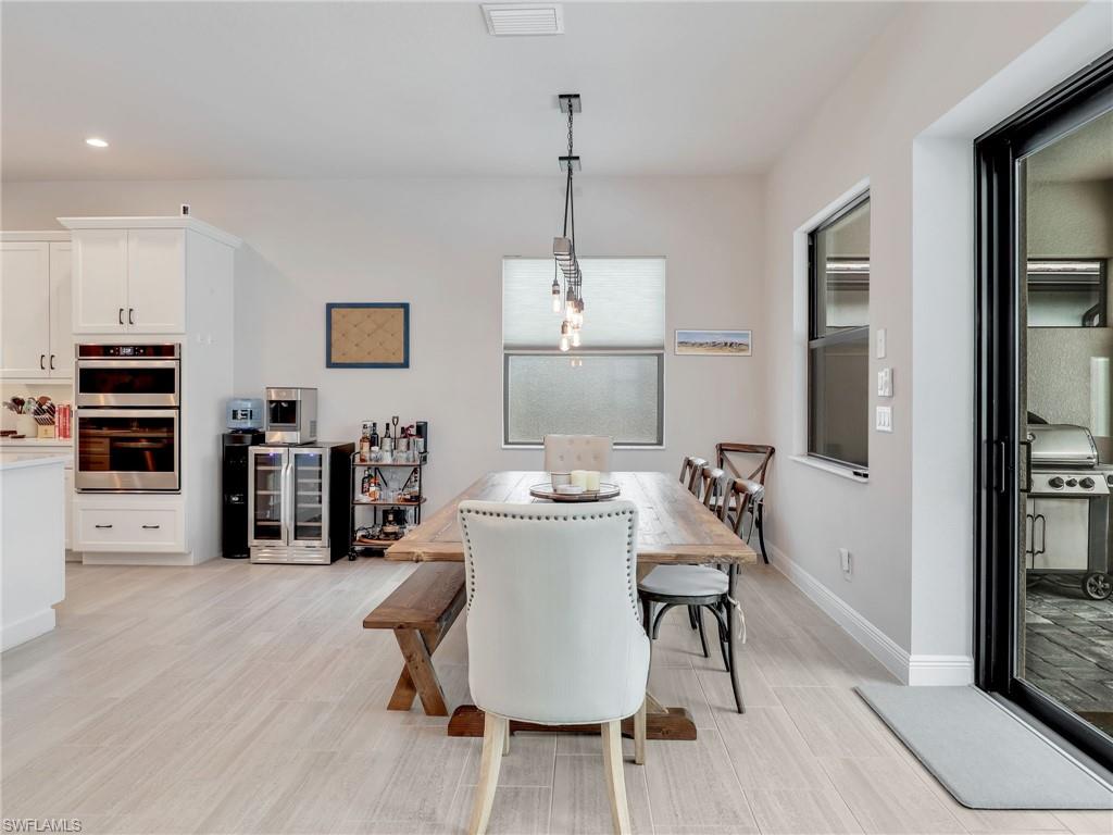 10047 Florence Circle Naples, FL 34119 - Photo 15 of 37 a view of a dining room with furniture and wooden floor