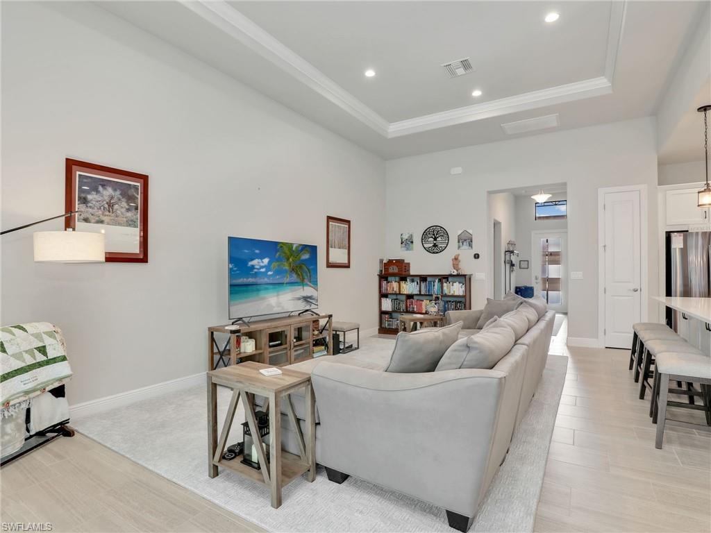 10047 Florence Circle Naples, FL 34119 - Photo 18 of 37 a living room with furniture a rug and a flat screen tv