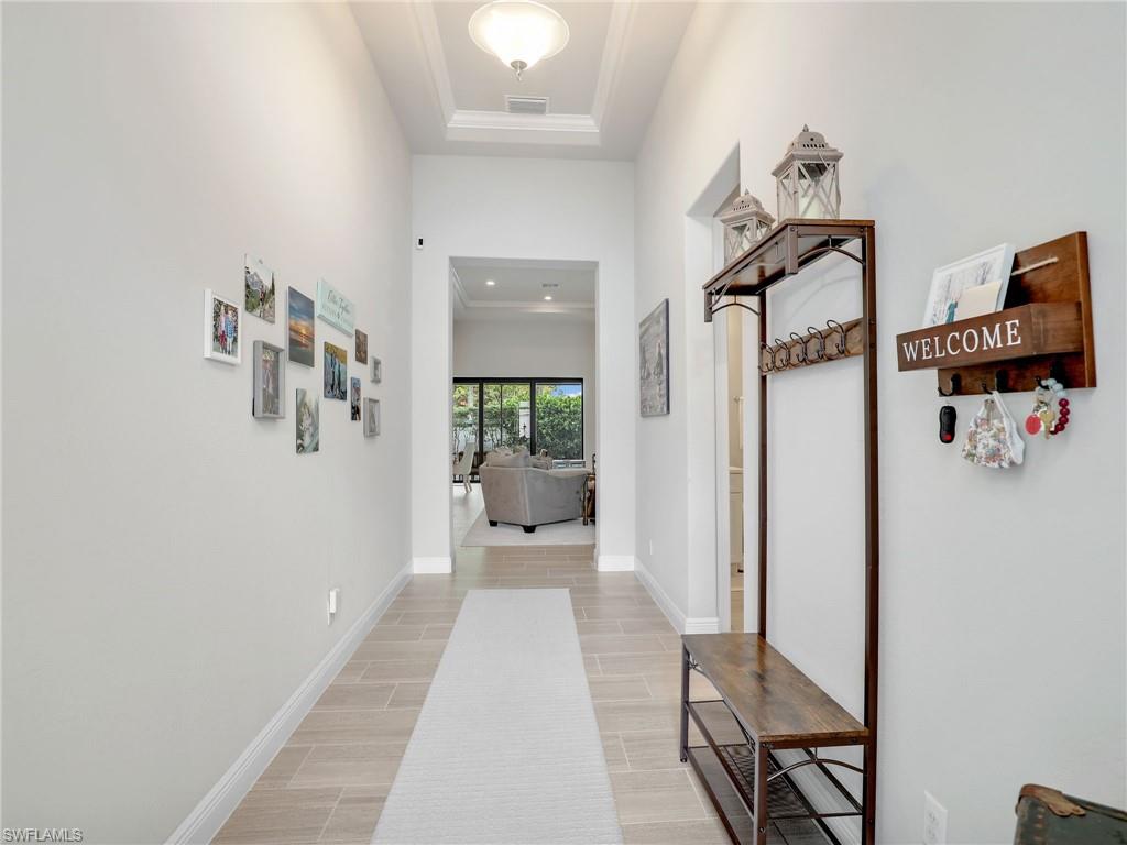 10047 Florence Circle Naples, FL 34119 - Photo 7 of 37 a hallway with a view of living room