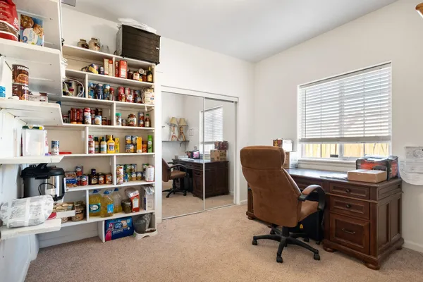 a view of a workspace with furniture and a window