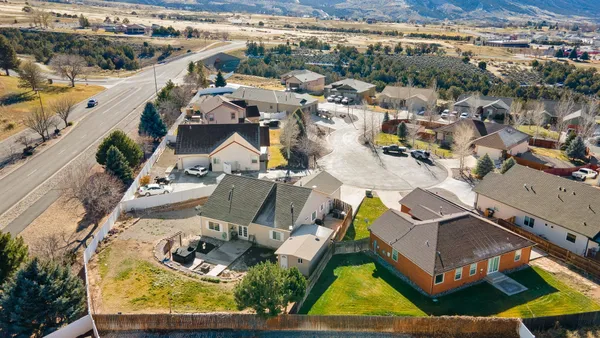 an aerial view of a house with a yard and lake view
