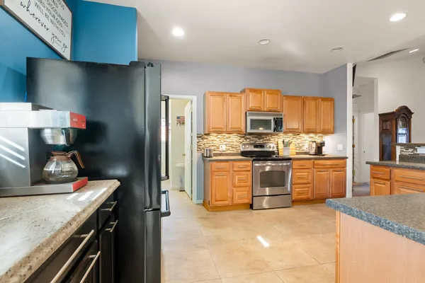 a kitchen with stainless steel appliances granite countertop a stove a sink and a refrigerator