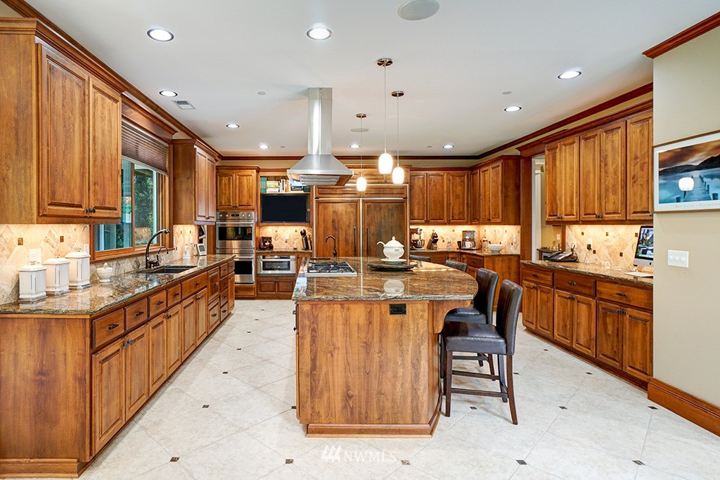 25205 Northeast 39th Way Redmond, WA 98053 - Photo 7 of 25 a kitchen with stainless steel appliances kitchen island granite countertop a stove top oven a sink a dining table and chairs