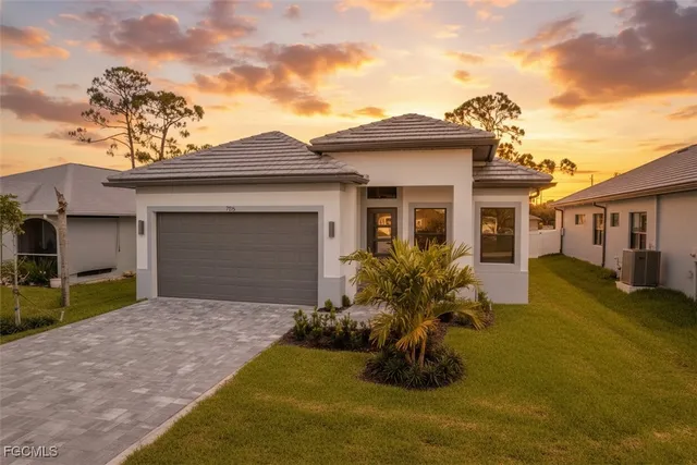 a front view of a house with a garden and yard