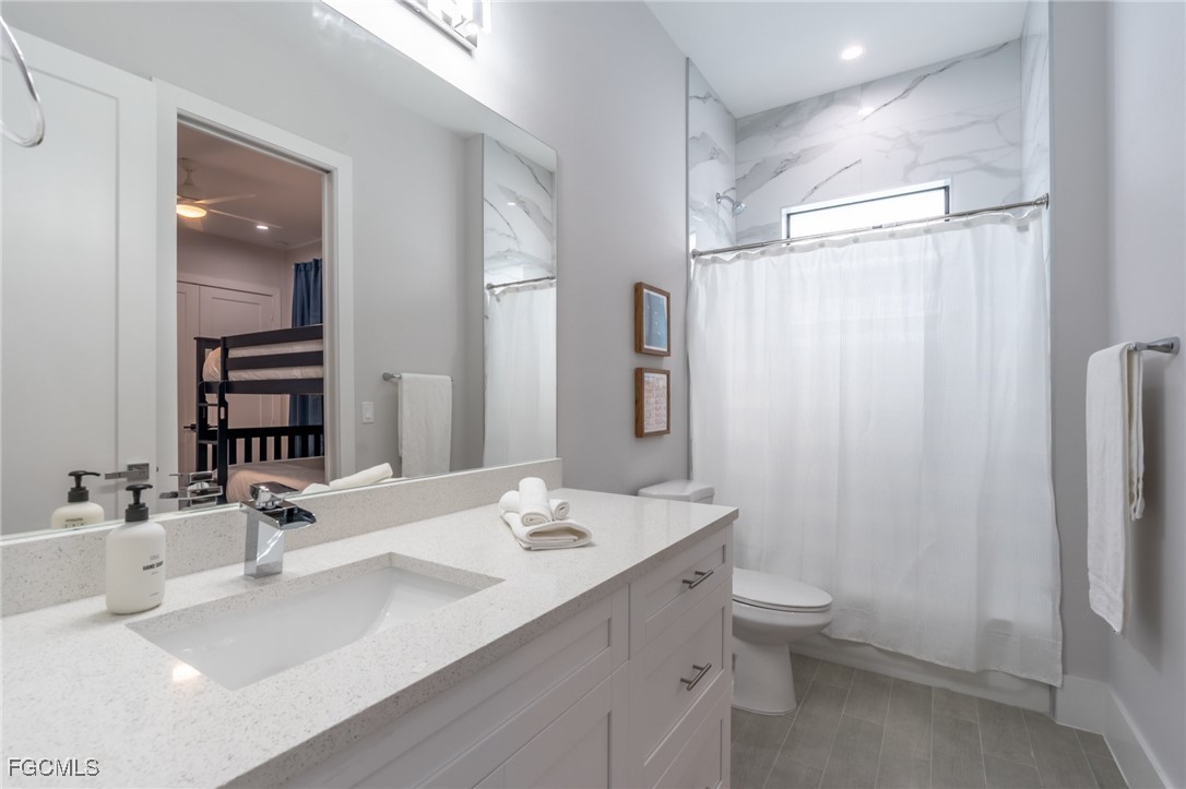 795 108th Avenue North Naples, FL 34108 - Photo 20 of 50 a bathroom with double vanity sink a toilet and a mirror