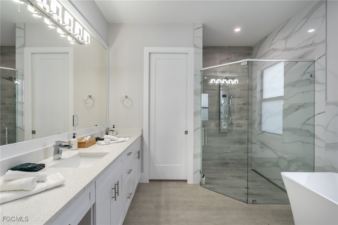 795 108th Avenue North Naples, FL 34108 - Photo 24 of 50 a spacious bathroom with a double vanity sink mirror and shower