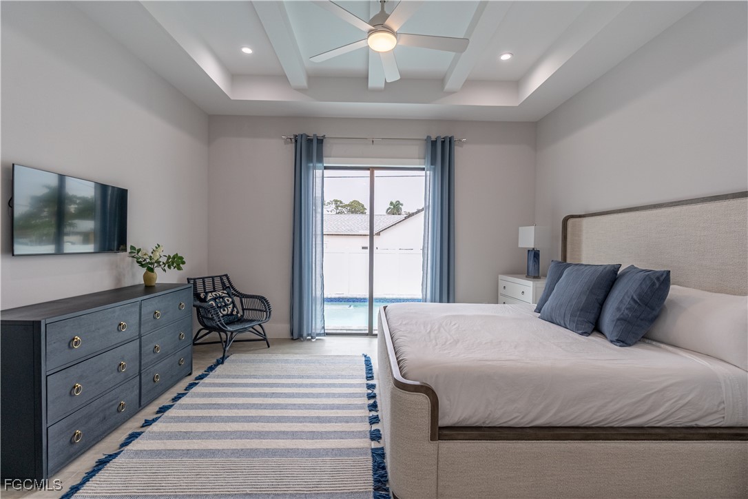 795 108th Avenue North Naples, FL 34108 - Photo 31 of 50 a bedroom with a large bed and a flat tv screen on dresser