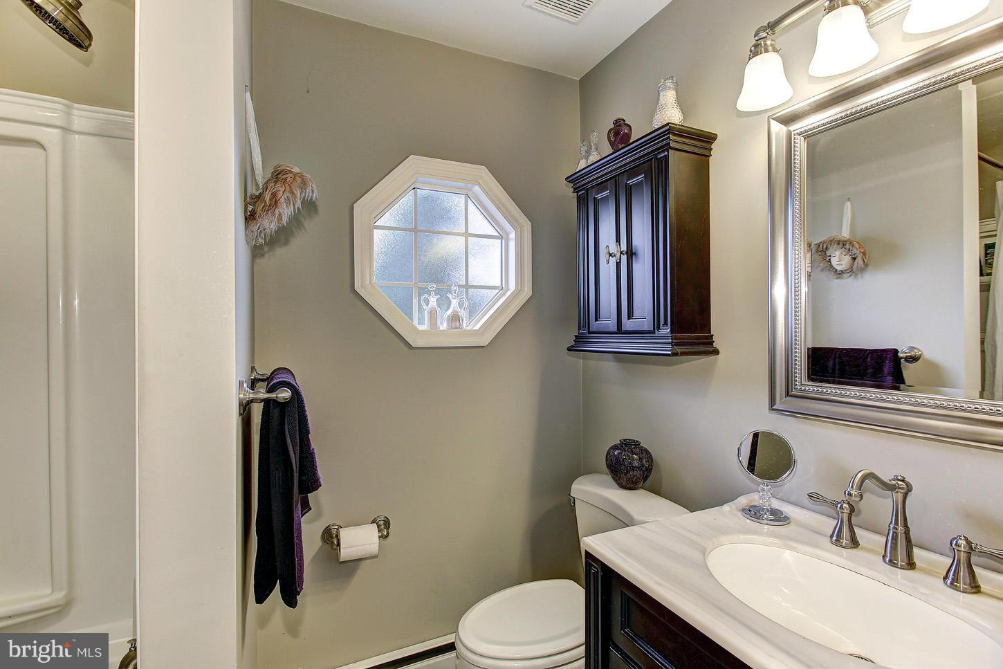 3701 Altondale Road Reisterstown, MD 21136 - Photo 16 of 29 a bathroom with a toilet sink vanity and mirror