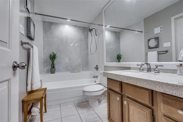a bathroom with a granite countertop sink toilet a mirror a vanity and shower