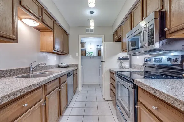a kitchen with stainless steel appliances granite countertop a sink stove and cabinets