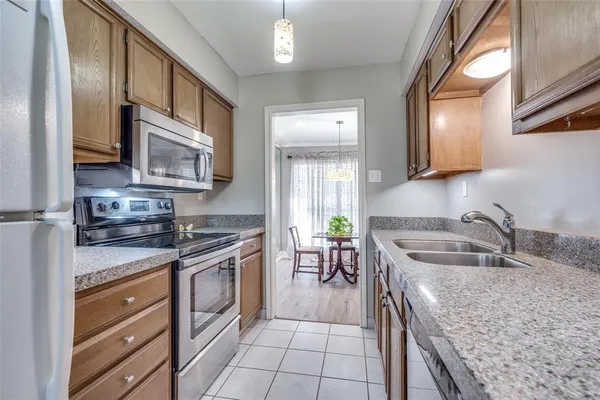 a kitchen with granite countertop a sink a stove and cabinets