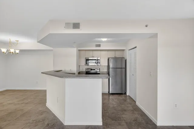 a kitchen with stainless steel appliances a refrigerator and a stove top oven