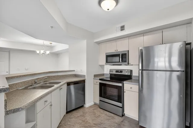 a kitchen with stainless steel appliances granite countertop a stove a refrigerator and a sink