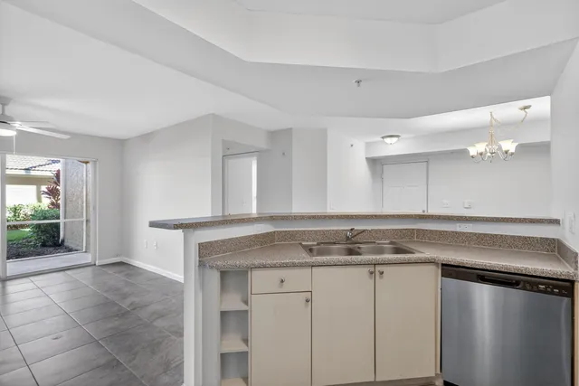 a view white cabinets a sink and dishwasher