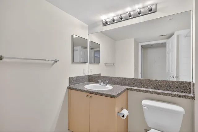 a en suite bathroom with a granite countertop sink and a mirror