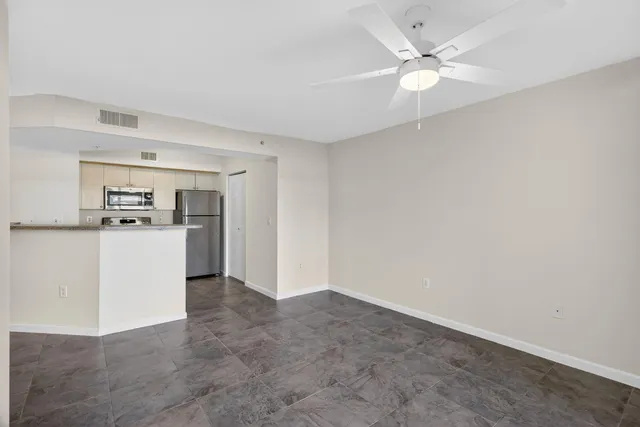 a view of a kitchen with refrigerator and white cabinets