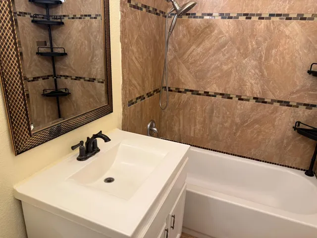 a bathroom with a granite countertop toilet and a sink