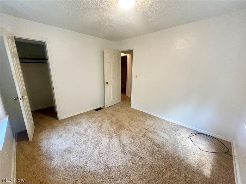 978 Cove Road Weirton, WV 26062 - Photo 10 of 18 Second view of 3rd bedroom featuring walk in closet, new carpet flooring, and a textured ceiling