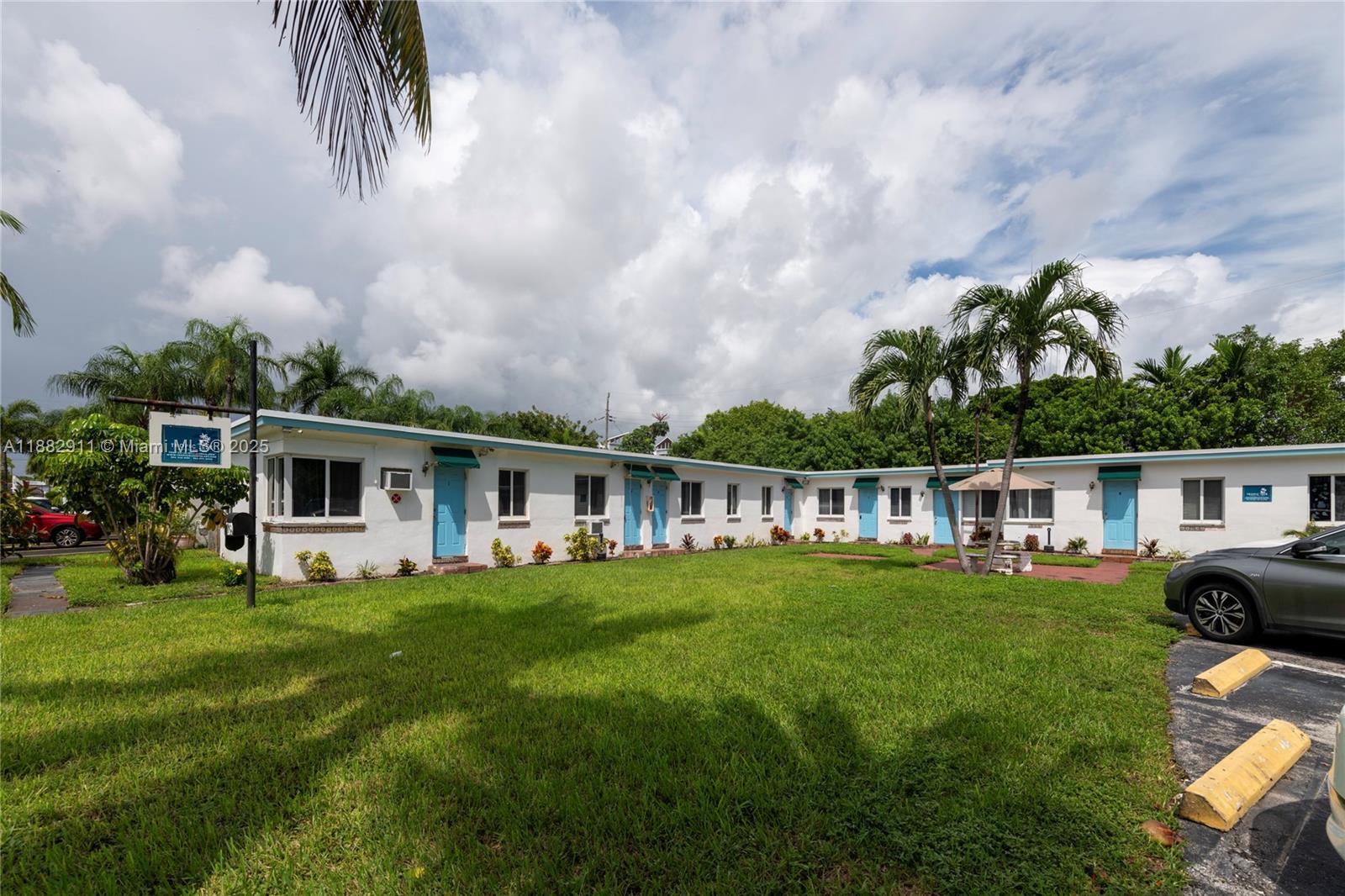 709 Northeast 2nd Court, Unit 19 Hallandale Beach, FL 33009 - Photo 1 of 12 a front view of a house with garden