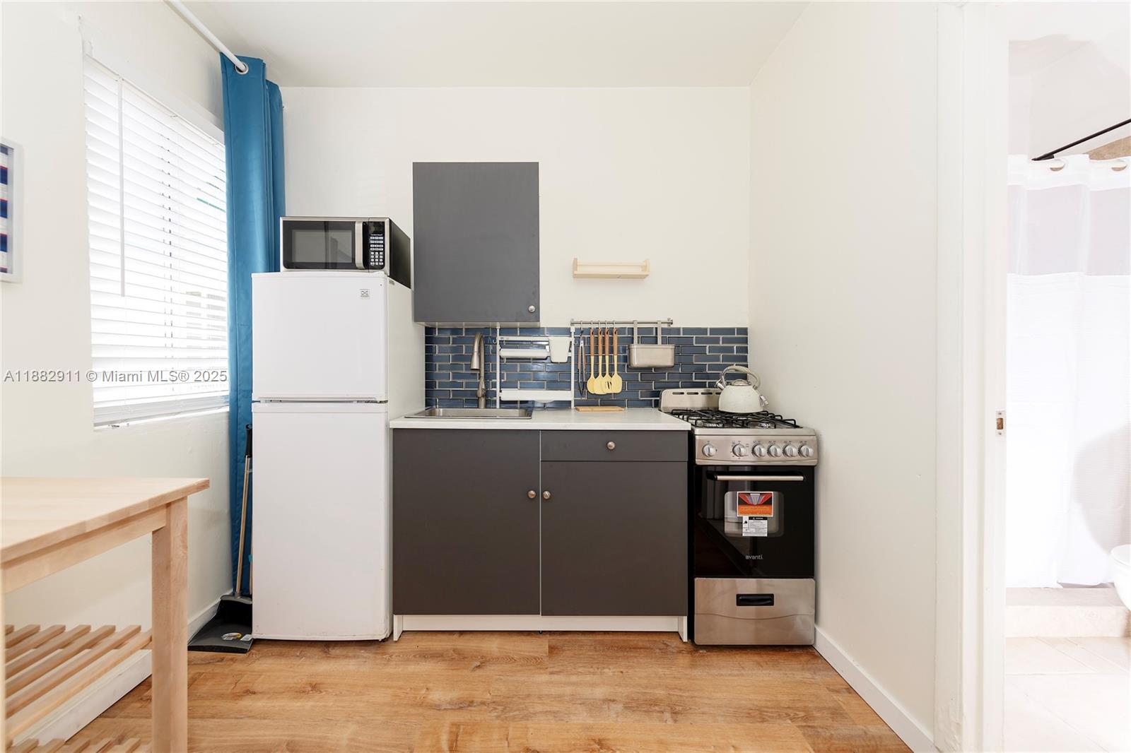 709 Northeast 2nd Court, Unit 19 Hallandale Beach, FL 33009 - Photo 11 of 12 a view of a kitchen with a fridge