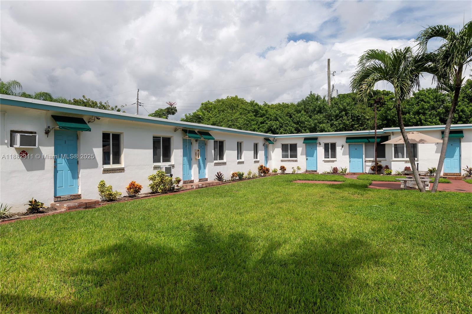 709 Northeast 2nd Court, Unit 19 Hallandale Beach, FL 33009 - Photo 2 of 12 a front view of house with yard and green space