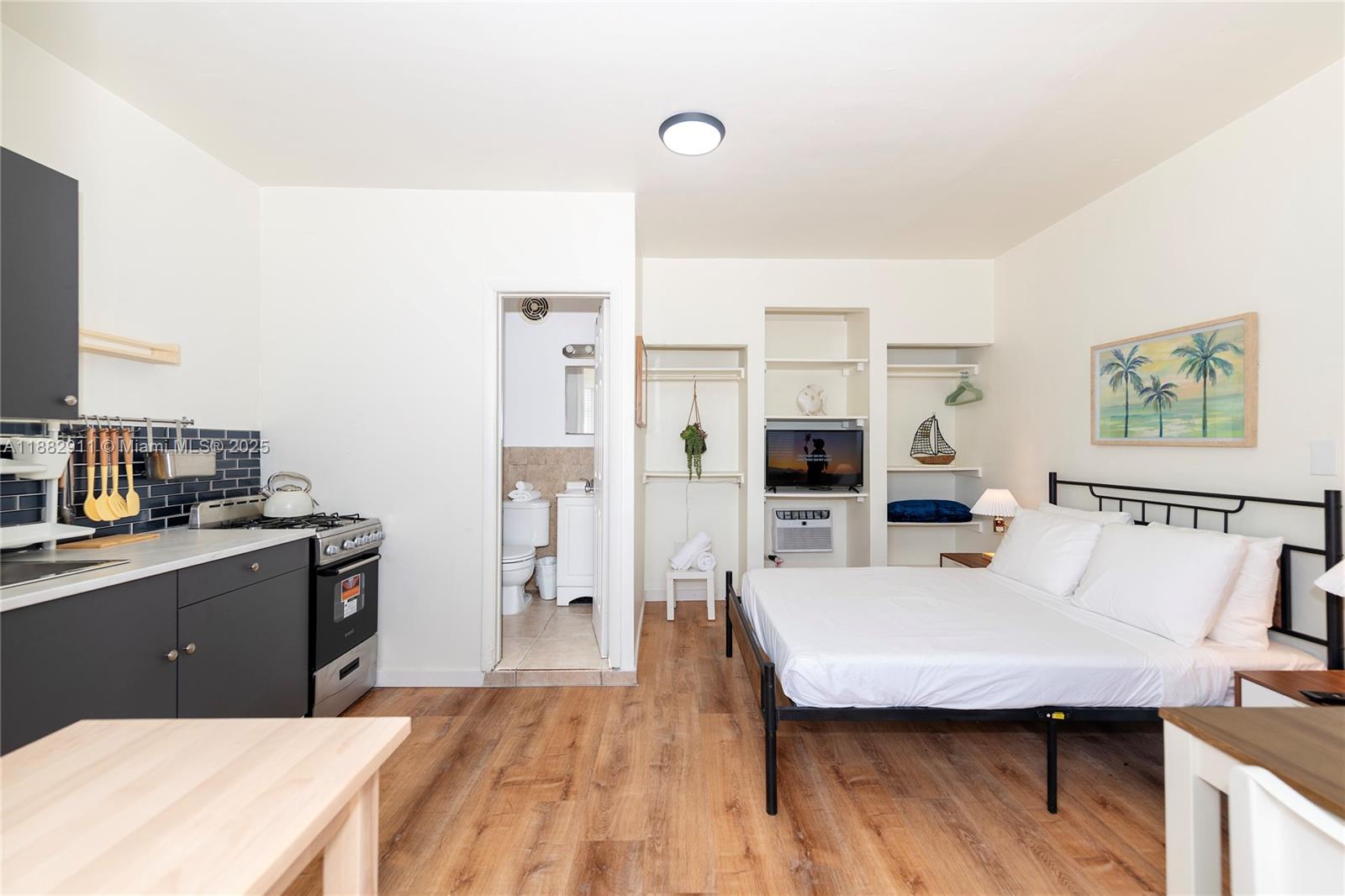 709 Northeast 2nd Court, Unit 19 Hallandale Beach, FL 33009 - Photo 4 of 12 a living room with stainless steel appliances kitchen island granite countertop a stove a sink dishwasher and a refrigerator with wooden floor