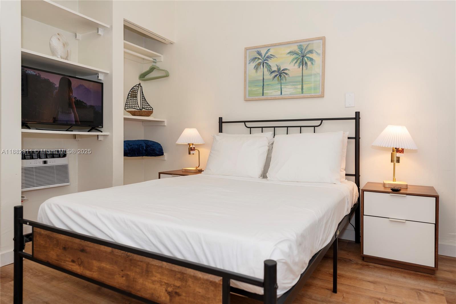 709 Northeast 2nd Court, Unit 19 Hallandale Beach, FL 33009 - Photo 7 of 12 a bedroom with a bed and a flat screen tv