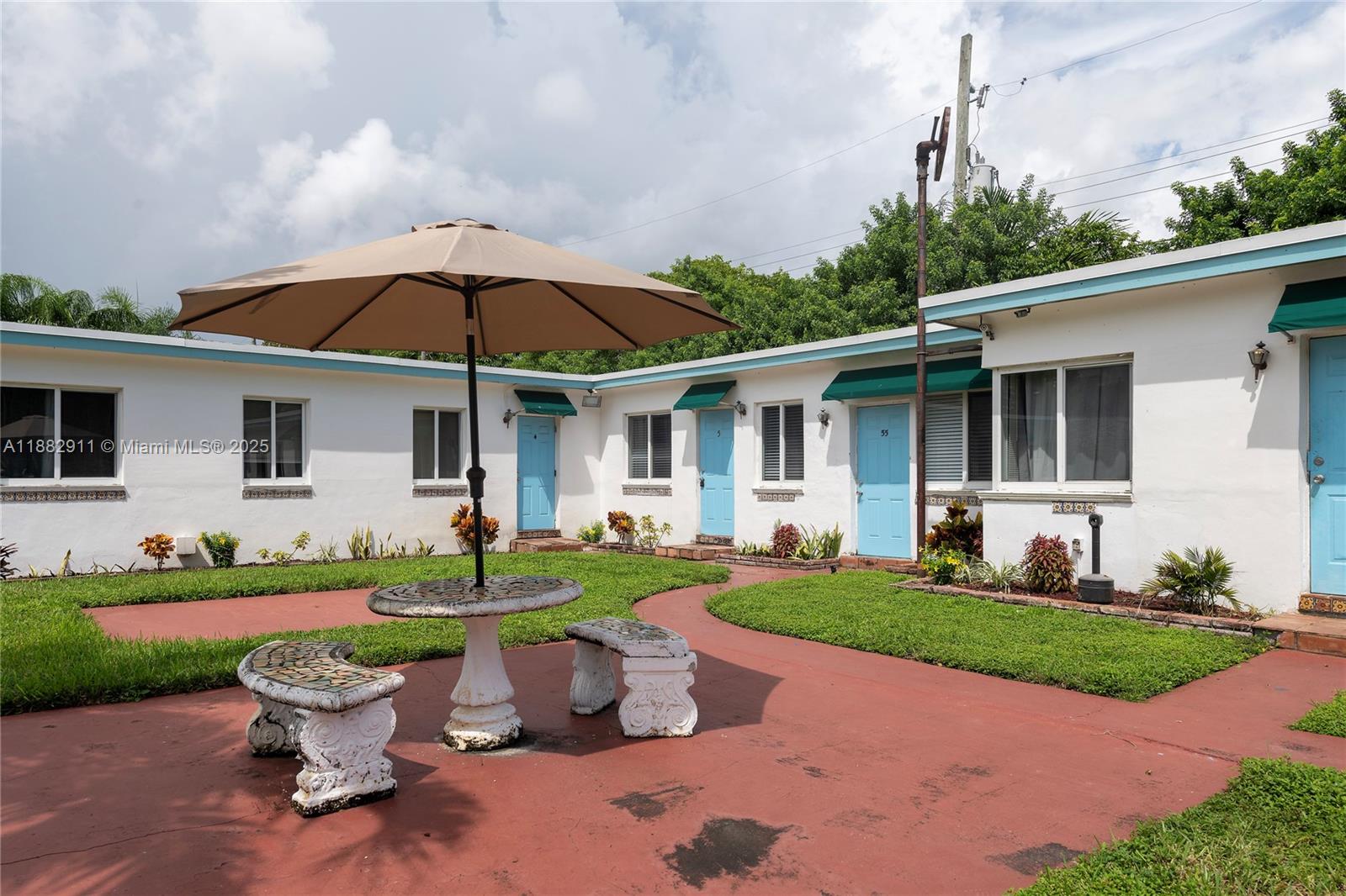 709 Northeast 2nd Court, Unit 19 Hallandale Beach, FL 33009 - Photo 8 of 12 a view of a house with backyard sitting area and garden