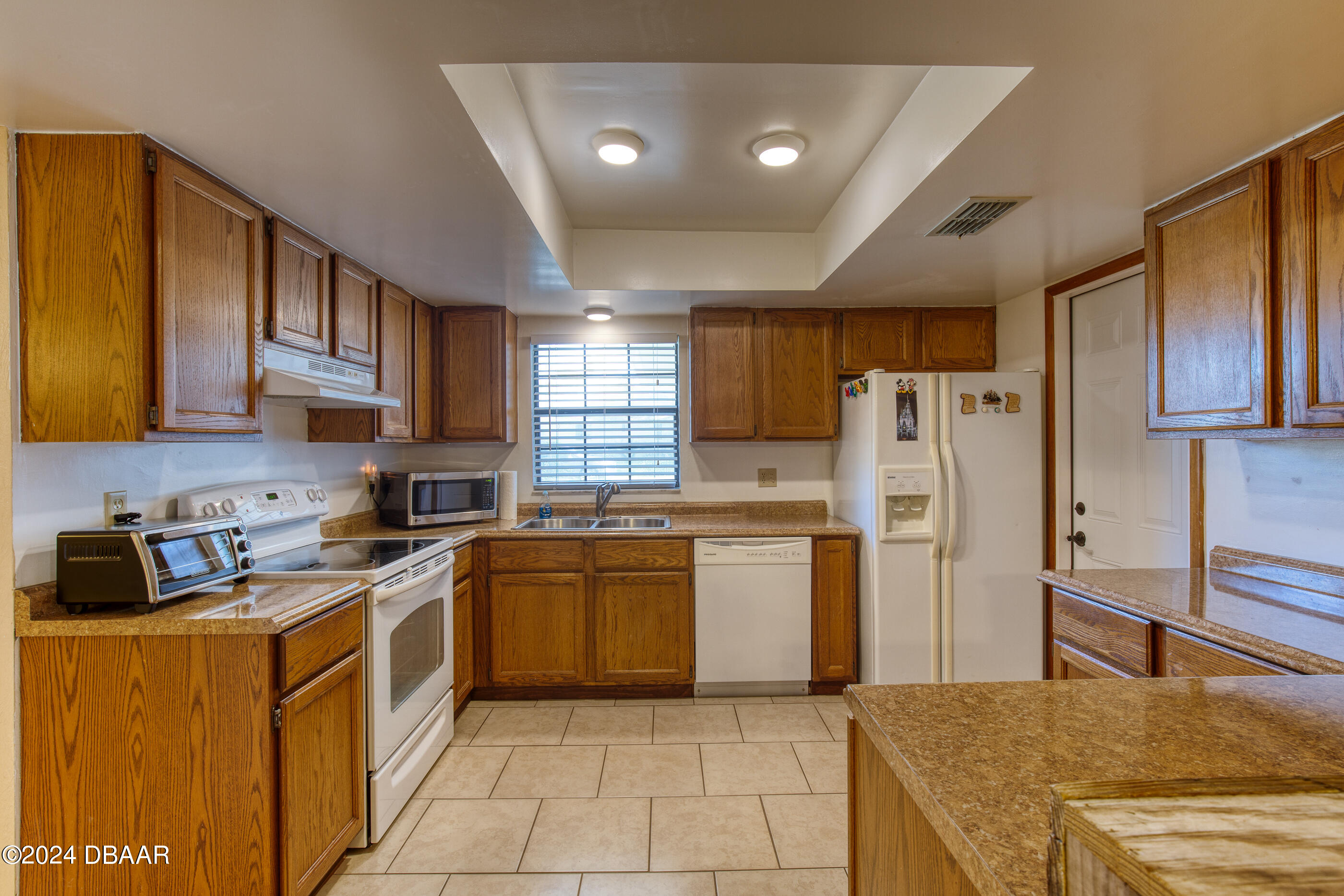 2304 Yule Tree Drive Edgewater, FL 32141 - Photo 15 of 34 a kitchen with a sink a refrigerator and cabinets