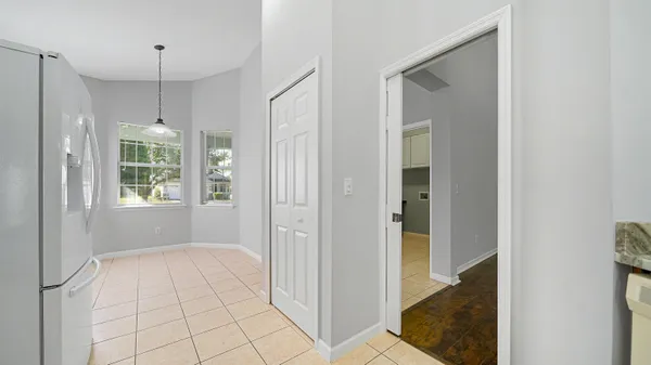 a view of an empty room with window and chandelier fan