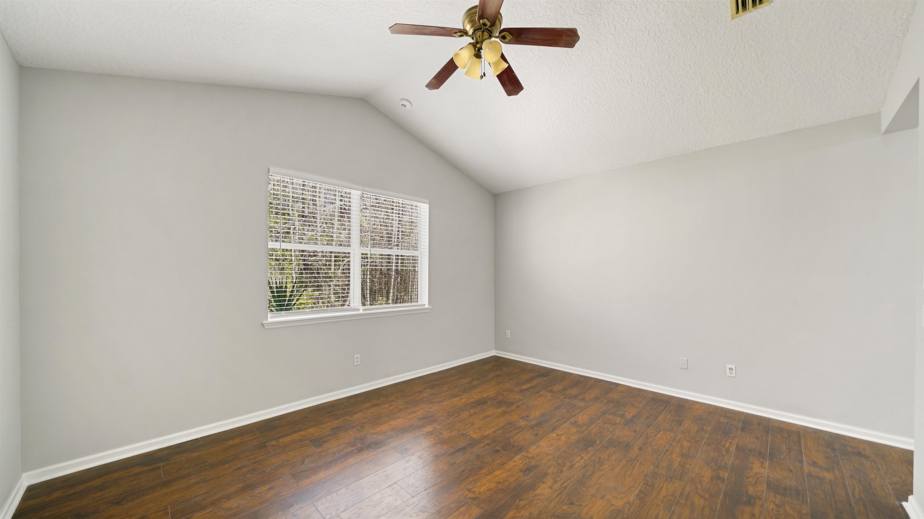778 Copperhead Circle St. Augustine, FL 32092 - Photo 13 of 35 an empty room with wooden floor ceiling fan and windows