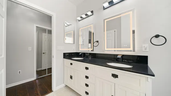 a bathroom with a granite countertop sink and a mirror