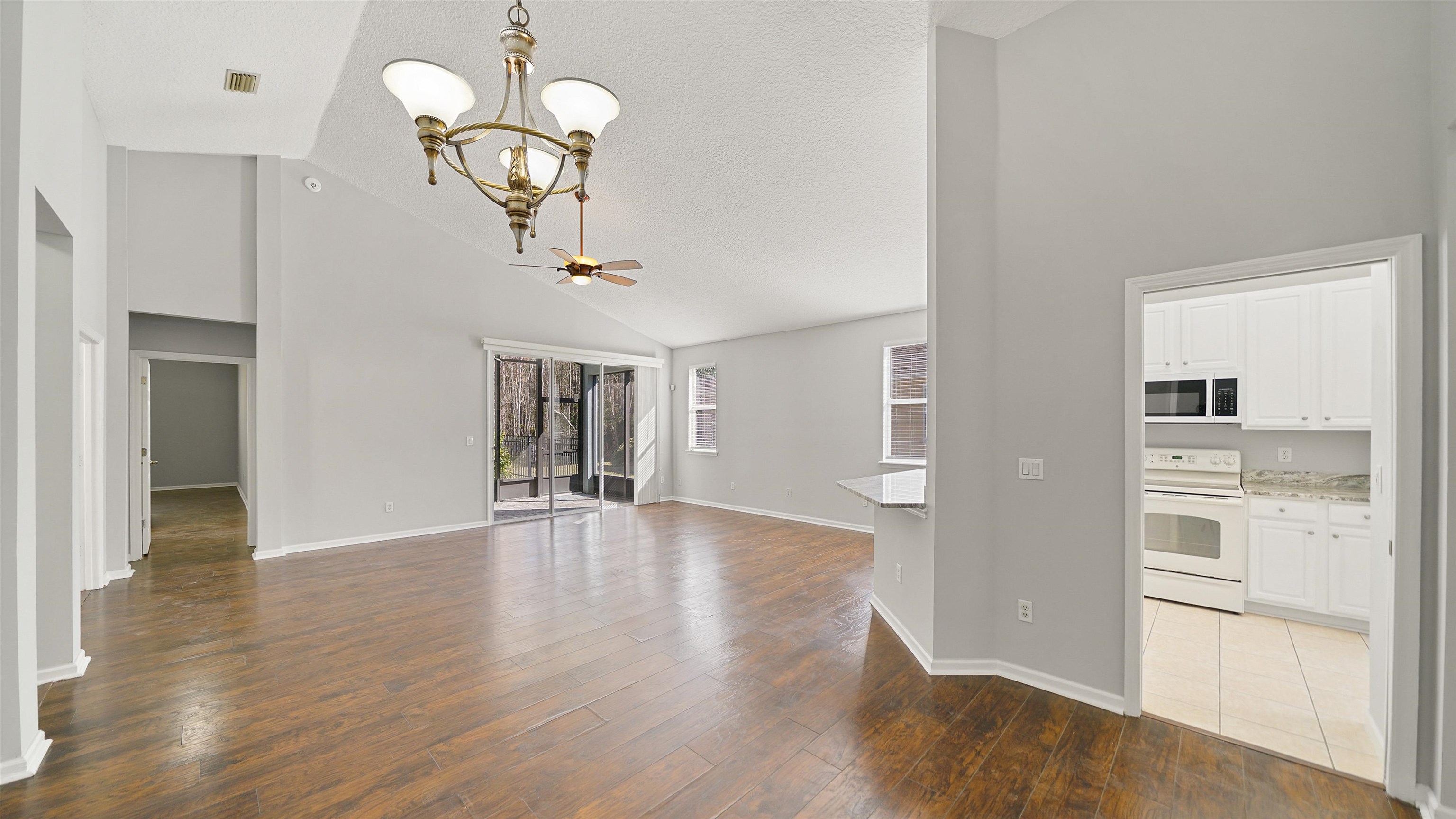 778 Copperhead Circle St. Augustine, FL 32092 - Photo 4 of 35 a view of a kitchen with wooden floor and a chandelier