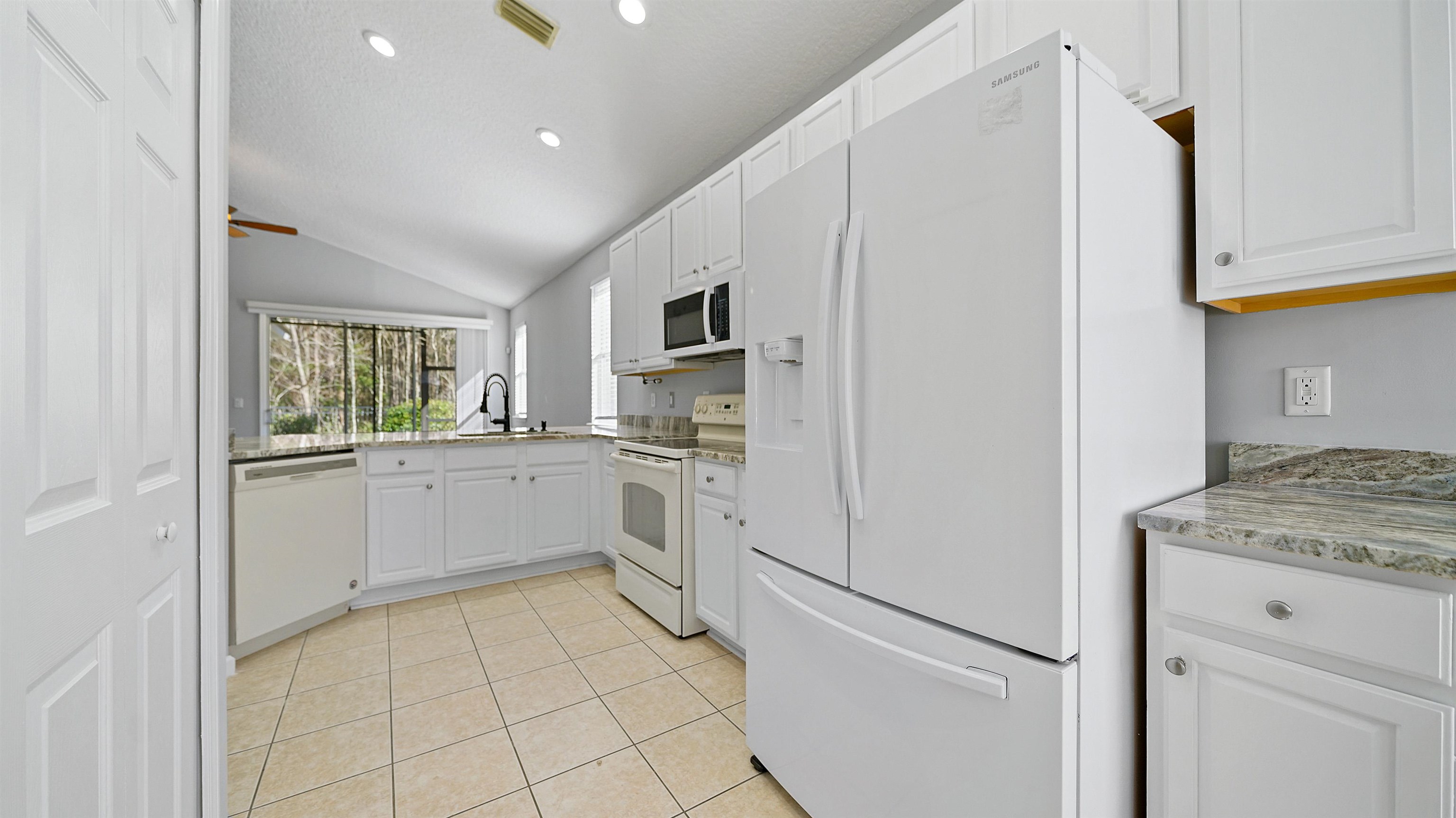 778 Copperhead Circle St. Augustine, FL 32092 - Photo 10 of 35 a kitchen with white cabinets and white appliances