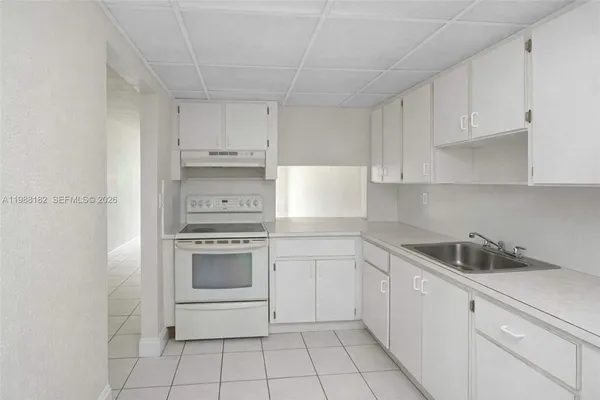 a kitchen with white cabinets and white appliances