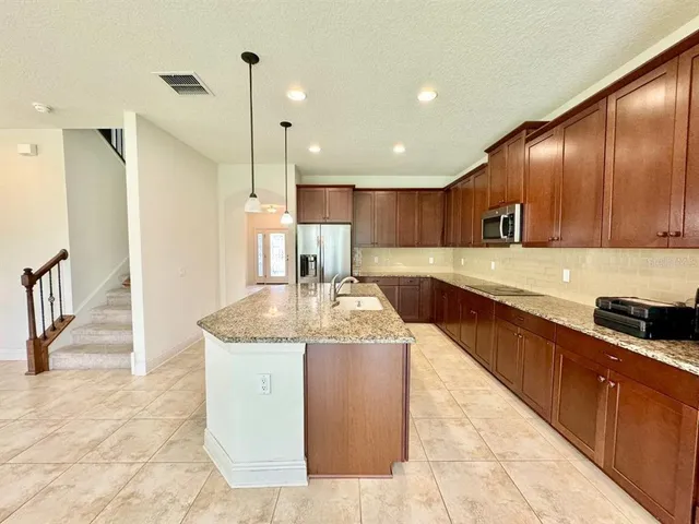 a view of a kitchen with a sink and a refrigerator