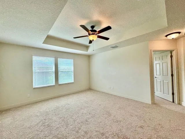 an empty room with windows and fan